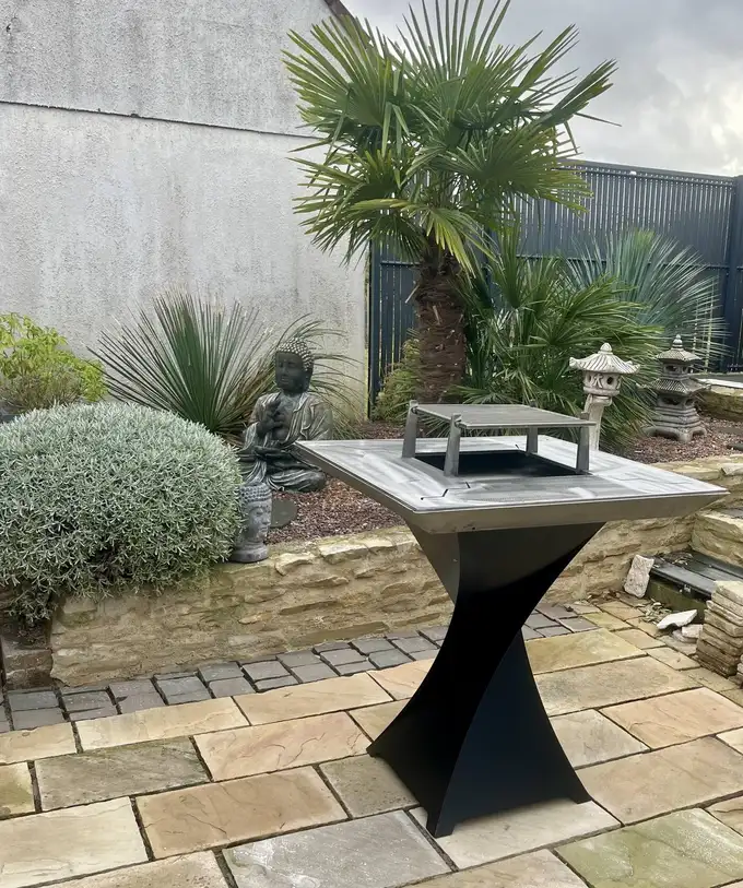 Brasero Signature centré en vue intégrale dans un jardin